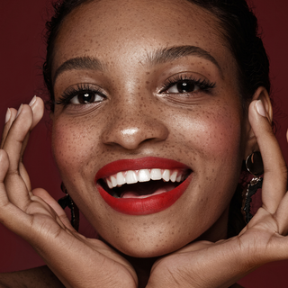 Model wearing Lady in Red makeup – bold red lips, warm fall tones, and flawless skin for a striking, on-trend autumn look.