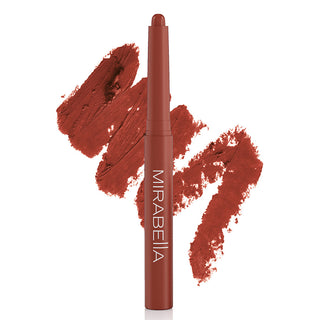 Image of Mirabella's bold Velvet Lip Crayon matte lip pencil shown upright in shade Nearly Nude with large shade swatch behind the pencil.