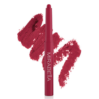 Image of Mirabella's bold Velvet Lip Crayon matte lip pencil shown upright in shade Raspberry Riot with large shade swatch behind the pencil.